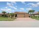 Beautiful home featuring a tile roof, three-car garage, and a well-manicured lawn with palm trees at 20323 Granlago Dr, Venice, FL 34293