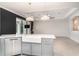 Bright kitchen featuring gray cabinets, white countertops, a stainless steel dishwasher, and access to the living room at 20323 Granlago Dr, Venice, FL 34293