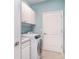 Well-lit laundry room with modern appliances, cabinets, and convenient door access at 20323 Granlago Dr, Venice, FL 34293