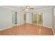 Bedroom with hardwood floors, ceiling fan, closet, and access to bathroom and sliding glass door at 1001 Meadowcrest Dr, Valrico, FL 33594