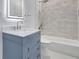 Bathroom featuring modern vanity, a stylish mirror, and a bathtub with tiled surround at 4413 W Wallcraft Ave, Tampa, FL 33611