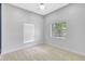 Cozy bedroom with neutral carpet, light gray walls, and two sunny windows with bright, natural light at 4413 W Wallcraft Ave, Tampa, FL 33611