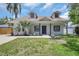 Charming home featuring a well-manicured lawn, complemented by mature palm trees and inviting curb appeal at 4413 W Wallcraft Ave, Tampa, FL 33611