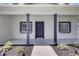 Inviting front entrance with well maintained landscaping, blue trim and dark blue door at 4413 W Wallcraft Ave, Tampa, FL 33611