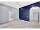 Spacious bedroom with a striking blue accent wall, plush carpet, and ensuite bathroom entrance at 4413 W Wallcraft Ave, Tampa, FL 33611