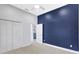 Large bedroom showcasing a blue accent wall and an ensuite bathroom entrance, offering comfort and style at 4413 W Wallcraft Ave, Tampa, FL 33611