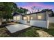 Backyard view of screened patio with exterior door and patio area at 8701 Thornwood Ln, Tampa, FL 33615