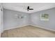 This bedroom features neutral walls, light wood floors, and a ceiling fan at 8701 Thornwood Ln, Tampa, FL 33615