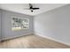 Bright bedroom featuring a large window offering plenty of natural light and wood floors at 8701 Thornwood Ln, Tampa, FL 33615
