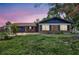Charming single-story brick home featuring a well-kept lawn and a cozy, inviting front facade at dusk at 8701 Thornwood Ln, Tampa, FL 33615