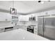 Modern kitchen featuring stainless steel appliances, white cabinetry, and a large island with breakfast bar seating at 8701 Thornwood Ln, Tampa, FL 33615