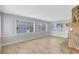Bright living room featuring a stone fireplace, wood floors, and large windows offering plenty of natural light at 8701 Thornwood Ln, Tampa, FL 33615