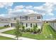 Aerial front view shows the well-manicured lawn, landscaped front yard, and three-car garage at 9201 Sanders Tree Loop, Wesley Chapel, FL 33545
