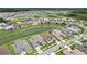 An aerial view showcases homes in a planned community nestled around a peaceful lake at 9201 Sanders Tree Loop, Wesley Chapel, FL 33545
