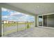 Spacious balcony featuring tile floors, modern railing, community view and sliding glass doors at 9201 Sanders Tree Loop, Wesley Chapel, FL 33545