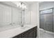 Bright bathroom with large mirror, modern vanity and walk-in shower at 9201 Sanders Tree Loop, Wesley Chapel, FL 33545