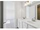 Bathroom featuring double sinks, vanity with white cabinets, and a large mirror at 9201 Sanders Tree Loop, Wesley Chapel, FL 33545