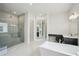 Luxurious bathroom features a glass shower, modern fixtures, soaking tub, and double vanities for ample space at 9201 Sanders Tree Loop, Wesley Chapel, FL 33545