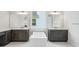 Elegant bathroom showcasing dual vanities with white marble countertops and a freestanding soaking tub at 9201 Sanders Tree Loop, Wesley Chapel, FL 33545
