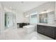 Luxurious primary bathroom featuring double vanities, soaking tub, expansive mirrors, and white marble floors at 9201 Sanders Tree Loop, Wesley Chapel, FL 33545