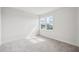 Bright bedroom with plush carpet and large window offering a view of the neighborhood at 9201 Sanders Tree Loop, Wesley Chapel, FL 33545