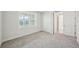 Carpeted bedroom features a closet, a large window and light colored walls at 9201 Sanders Tree Loop, Wesley Chapel, FL 33545