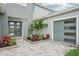 Front of a home with modern double doors and well manicured yard with fresh landscape at 9201 Sanders Tree Loop, Wesley Chapel, FL 33545