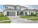 Modern home with a two-car garage and well-kept lawn with a beautiful driveway at 9201 Sanders Tree Loop, Wesley Chapel, FL 33545