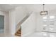 Bright foyer featuring staircase, modern chandelier, and entrance showcasing the high ceilings at 9201 Sanders Tree Loop, Wesley Chapel, FL 33545