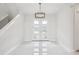 Bright foyer with high ceilings, white tile flooring, a modern chandelier, and staircase at 9201 Sanders Tree Loop, Wesley Chapel, FL 33545
