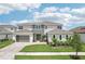 Charming home with a three-car garage, landscaped front yard, and brick-paved driveway at 9201 Sanders Tree Loop, Wesley Chapel, FL 33545