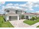 Charming home with a three-car garage, landscaped front yard, and brick-paved driveway at 9201 Sanders Tree Loop, Wesley Chapel, FL 33545
