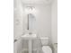 Stylish half bathroom features a pedestal sink, modern lighting, and tiled flooring at 9201 Sanders Tree Loop, Wesley Chapel, FL 33545