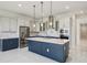 Modern kitchen features stainless steel appliances, island with pendant lights and quartz countertops at 9201 Sanders Tree Loop, Wesley Chapel, FL 33545