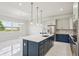 Bright, open kitchen features a large island with pendant lighting, stainless appliances, and eat-in area at 9201 Sanders Tree Loop, Wesley Chapel, FL 33545