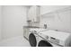 Well-equipped laundry room with modern washer and dryer, granite countertop and ample storage at 9201 Sanders Tree Loop, Wesley Chapel, FL 33545
