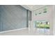 Bright living room boasts a decorative accent wall, high ceilings, and sliding glass doors at 9201 Sanders Tree Loop, Wesley Chapel, FL 33545
