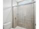 Walk-in shower with glass doors and gray tile at 9201 Sanders Tree Loop, Wesley Chapel, FL 33545