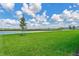 Expansive backyard with lush green grass, offering serene water views and ample space for outdoor enjoyment at 17127 Harvest Moon Way, Bradenton, FL 34211