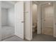 Neutral-toned bathroom featuring a toilet, tile floors, and views into the bedroom and closet at 17127 Harvest Moon Way, Bradenton, FL 34211
