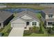 Charming single-Gathering home featuring a two-car garage, complemented by lush landscaping, and a serene water view at 17127 Harvest Moon Way, Bradenton, FL 34211