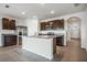 Bright and airy kitchen with dark cabinets, granite countertops, stainless steel appliances, and seamless transition to entryway at 17127 Harvest Moon Way, Bradenton, FL 34211