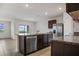 Modern kitchen with a stainless steel refrigerator, granite countertops, and a functional center island for meal preparation at 17127 Harvest Moon Way, Bradenton, FL 34211