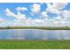 Scenic pond view with clear skies above and lush green grass in the foreground, perfect for relaxation and enjoyment at 17127 Harvest Moon Way, Bradenton, FL 34211