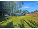 Spacious backyard with lush green grass, a wood fence, and shade trees at 5141 Mallet Dr, Port Richey, FL 34668