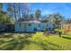 Fully fenced backyard with lawn, firepit, grill and tropical landscaping provides a relaxing outdoor space at 5141 Mallet Dr, Port Richey, FL 34668