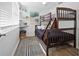 Charming bedroom features a wooden bunk bed, striped rug, and bright natural light through window at 5141 Mallet Dr, Port Richey, FL 34668