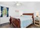 Bedroom with wood sleigh bed, side table, ceiling fan, and natural light at 5141 Mallet Dr, Port Richey, FL 34668