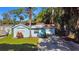 Charming single-story home with a well-maintained lawn, lush trees, and a gravel driveway at 5141 Mallet Dr, Port Richey, FL 34668