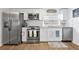 Bright kitchen features stainless steel appliances, white cabinets, granite countertops, and wood-look flooring at 5141 Mallet Dr, Port Richey, FL 34668